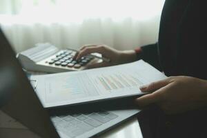 Close up businessman hand using calculator and working with laptop calculate about finance accounting at coffeeshop outdor.finance accounting concept photo