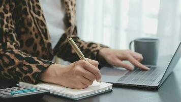 schot van een Aziatisch jong bedrijf vrouw werken Aan laptop in haar werkstation. video