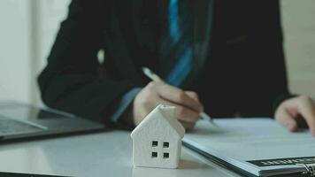 Real estate agent and customer signing contract to buy house, insurance or loan real estate.rent a house,get insurance or loan real estate or property. video