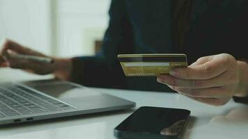 donne Tenere credito carta e utilizzando smartphone a casa.online acquisti, Internet bancario, memorizzare in linea, pagamento, la spesa i soldi, e-commerce pagamento a il negozio, credito carta, concetto video