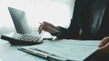 Close up businessman hand using calculator and working with laptop calculate about finance accounting at coffeeshop outdor.finance accounting concept video