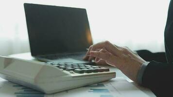 cierre la mano del hombre de negocios usando una calculadora y trabajando con una computadora portátil para calcular la contabilidad financiera en la cafetería outdor.concepto de contabilidad financiera video