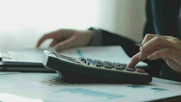 primo piano la mano dell'uomo d'affari utilizzando la calcolatrice e lavorando con il laptop calcolare la contabilità finanziaria al coffeeshop outdor.concetto di contabilità finanziaria video