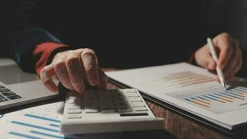 primo piano la mano dell'uomo d'affari utilizzando la calcolatrice e lavorando con il laptop calcolare la contabilità finanziaria al coffeeshop outdor.concetto di contabilità finanziaria video