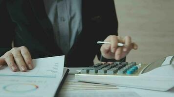 Close up businessman hand using calculator and working with laptop calculate about finance accounting at coffeeshop outdor.finance accounting concept video