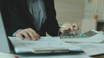 primo piano la mano dell'uomo d'affari utilizzando la calcolatrice e lavorando con il laptop calcolare la contabilità finanziaria al coffeeshop outdor.concetto di contabilità finanziaria video