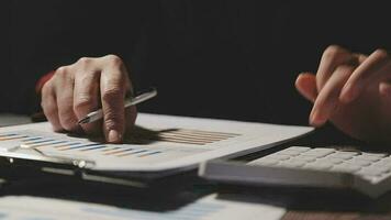 primo piano la mano dell'uomo d'affari utilizzando la calcolatrice e lavorando con il laptop calcolare la contabilità finanziaria al coffeeshop outdor.concetto di contabilità finanziaria video