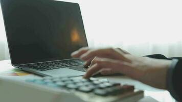 primo piano la mano dell'uomo d'affari utilizzando la calcolatrice e lavorando con il laptop calcolare la contabilità finanziaria al coffeeshop outdor.concetto di contabilità finanziaria video