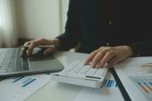 Close up businessman hand using calculator and working with laptop calculate about finance accounting at coffeeshop outdor.finance accounting concept photo