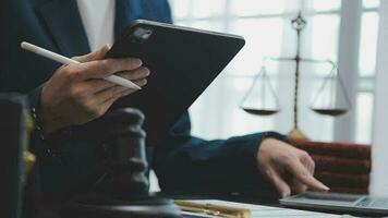 Justice and law concept.Male judge in a courtroom with the gavel, working with, computer and docking keyboard, eyeglasses, on table in morning light video