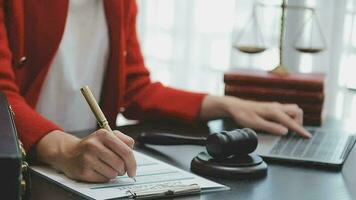Justice and law concept.Male judge in a courtroom with the gavel, working with, computer and docking keyboard, eyeglasses, on table in morning light video