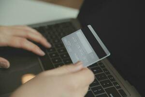 Woman hands holding and using cradit card for shopping online. photo