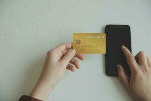 manos de mujer sosteniendo y usando tarjeta de crédito para comprar en línea. foto
