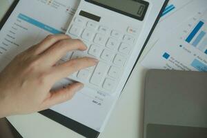 Unrecognizable businessman using calculator photo