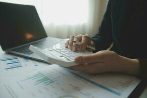 Unrecognizable businessman using calculator photo