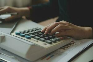 Unrecognizable businessman using calculator photo