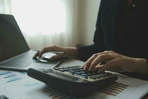 Unrecognizable businessman using calculator photo