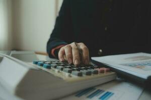 Unrecognizable businessman using calculator photo