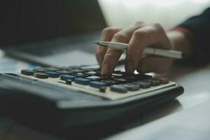 Unrecognizable businessman using calculator photo