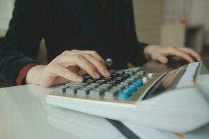 Unrecognizable businessman using calculator photo