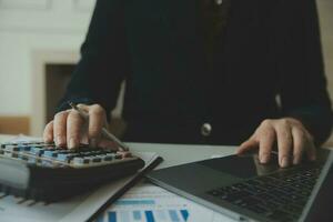 Unrecognizable businessman using calculator photo