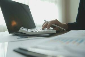 Unrecognizable businessman using calculator photo