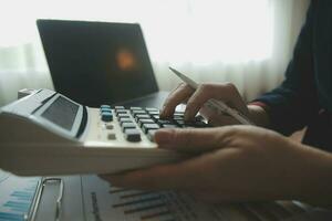 Unrecognizable businessman using calculator photo