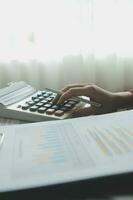 Unrecognizable businessman using calculator photo