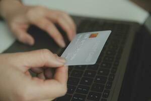 concepto de pago en línea con tarjeta de crédito. mano de hombres que usan una computadora portátil para hacer el pago de un seguro de salud en línea. foto