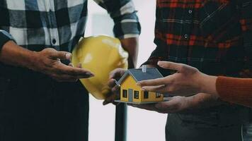 costruzione e struttura concetto di ingegnere Lavorando disegno su planimetria incontro per progetto Lavorando con compagno su modello edificio e ingegneria utensili nel Lavorando luogo, costruzione concetto. video