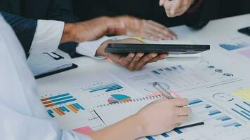 Financial analysts analyze business financial reports on a digital tablet planning investment project during a discussion at a meeting of corporate showing the results of their successful teamwork. video