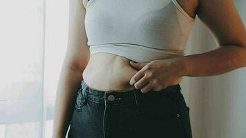 mujer gorda, barriga gorda, gordita, mujer obesa mano sosteniendo grasa abdominal excesiva con cinta métrica, concepto de estilo de vida de dieta de mujer video