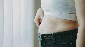 grosse femme, gros ventre, joufflu, main de femme obèse tenant la graisse du ventre excessive avec ruban à mesurer, concept de mode de vie de régime alimentaire femme video