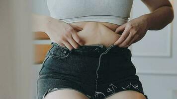 mujer gorda, barriga gorda, gordita, mujer obesa mano sosteniendo grasa abdominal excesiva con cinta métrica, concepto de estilo de vida de dieta de mujer video