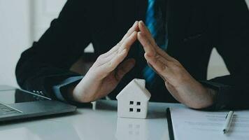 Female woman hands holding home model, small miniature white toy house. Mortgage property insurance dream moving home and real estate concept video