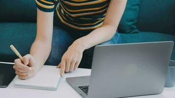 portret van Aziatische jonge vrouw die op laptop op kantoor werkt video