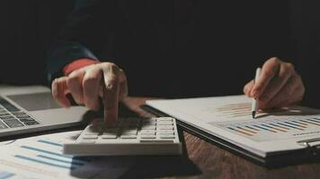 Close up businessman hand using calculator and working with laptop calculate about finance accounting at coffeeshop outdor.finance accounting concept video