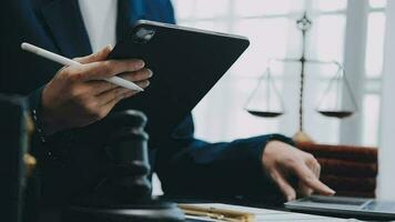 Justice and law concept.Male judge in a courtroom with the gavel, working with, computer and docking keyboard, eyeglasses, on table in morning light video