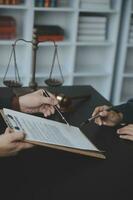 Male lawyer working with contract papers and wooden gavel on tabel in courtroom. justice and law ,attorney, court judge, concept. photo