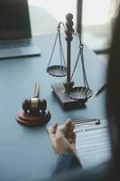 Male lawyer working with contract papers and wooden gavel on tabel in courtroom. justice and law ,attorney, court judge, concept. photo