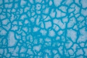 Blue abstract pattern texture background with cracks and holes. Close up. photo