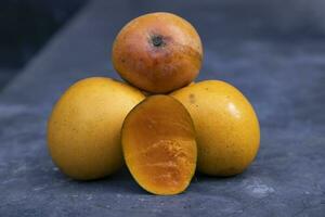 Ripe mango fruits on a dark background. Close-up photo