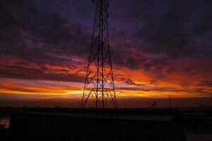 High voltage power line tower with beautiful sky at sunset, stock photo