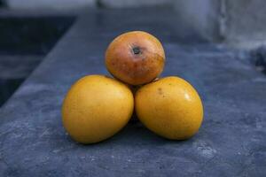 Ripe mangoes on a black stone background. Selective focus photo