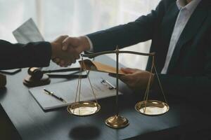 Business and lawyers discussing contract papers with brass scale on desk in office. Law, legal services, advice, justice and law concept picture with film grain effect photo