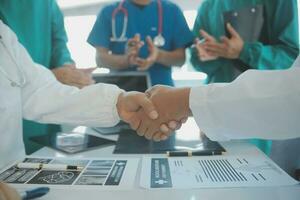 Doctors and nurses in a medical team stacking hands photo