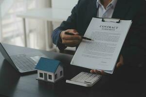 Real estate agent and customer signing contract to buy house, insurance or loan real estate.rent a house,get insurance or loan real estate or property. photo