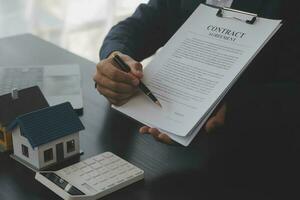 Real estate agent and customer signing contract to buy house, insurance or loan real estate.rent a house,get insurance or loan real estate or property. photo