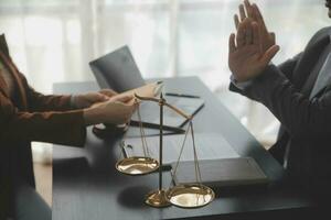 Justice and law concept.Male judge in a courtroom with the gavel, working with, computer and docking keyboard, eyeglasses, on table in morning light photo