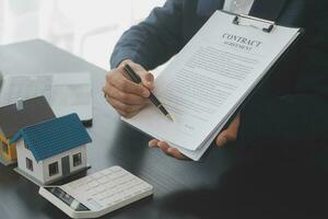 Real estate agent and customer signing contract to buy house, insurance or loan real estate.rent a house,get insurance or loan real estate or property. photo